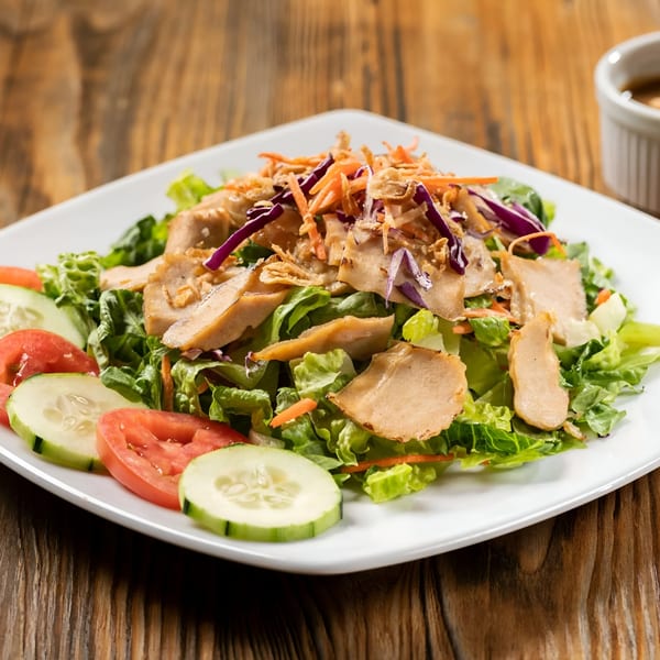 Sen Noodle House's Asian-fusion salad with chicken, lettuce, cucumbers, tomatoes, and shredded vegetables.